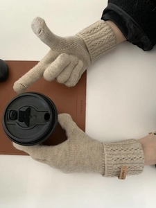 Gros plan de gants d'hiver en tricot beige avec des ouvertures tactiles fonctionnelles