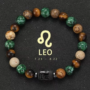 Macro shot of Leo zodiac charm on tiger eye and green agate beaded stretch bracelet