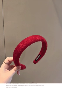 Close-up of red velvet padded headband featuring a stitched Hand Made inner fabric label