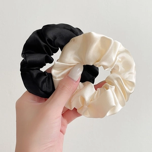 Set of two silk texture scrunchies in black and off-white colors for hair styling