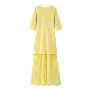 Detail of yellow dress with knitted short sleeve top and pleated chiffon skirt texture