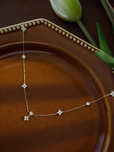 Detail of 18K gold plated silver four-leaf clover necklace with sparkling zircon pavé
