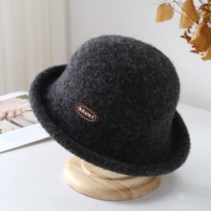 Elegant dark grey wool bucket hat with brown BRUHT embroidery patch on a wooden stand