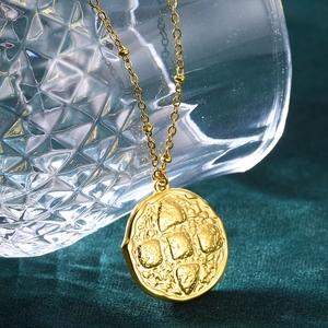 Detail view of gold irregular textured pendant with hammered finish on metal necklace
