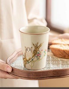 Detail of Ru Kiln ceramic teacup featuring cat illustration and ice-crack glaze texture