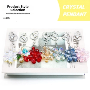 Flat lay of crystal flower keychains in seven vibrant colors on an open vintage book