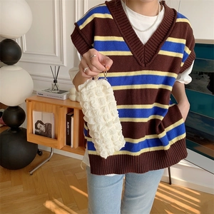Close-up of cream textured bubble pouch being held, featuring soft pleated knit material
