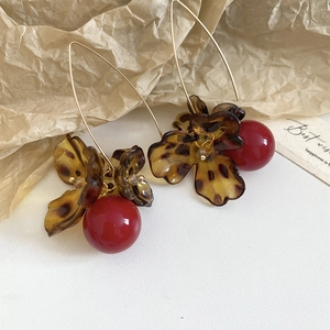 Detail of vintage leopard print acetate flower earrings with a dark red pearl pendant