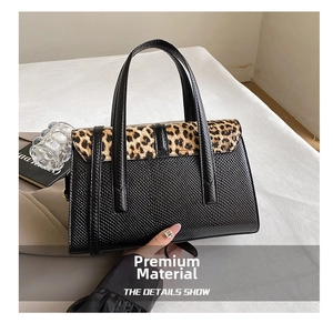 Detail shot of the contrast handbag featuring leopard print pony hair and faux lizard leather