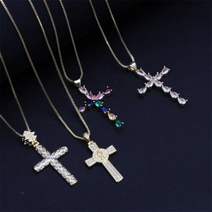 Detail of four gold plated cross necklaces with colorful zircons on black background