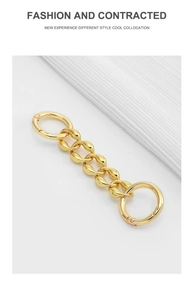 Close-up of golden metal chain strap with circular spring clasps for handbag renovation
