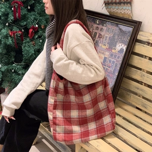 Detail of red and white plaid tote bag made of thick fabric in a cozy holiday setting