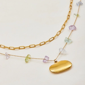 Layered gold paperclip necklace featuring colorful natural stones and an oval pebble pendant