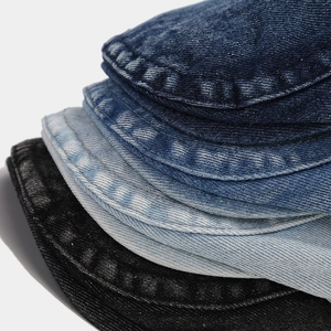 Macro detail of distressed denim flat caps showing stitched edges and twill texture