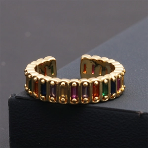 Gros plan d'une bague dorée ajustable sertie de pierres multicolores de taille baguette