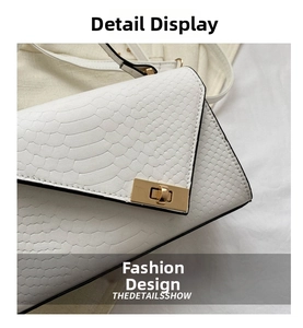 Close-up of white faux snakeskin embossed leather and rectangular gold metal twist lock
