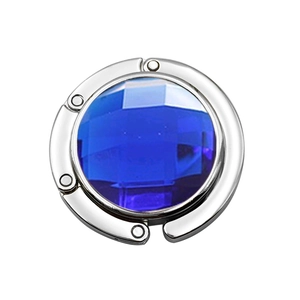 Close-up of portable round bag hook with faceted blue crystal and silver metal finish
