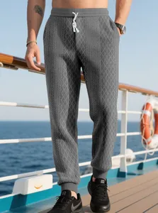 Dettaglio dei pantaloni sportivi grigi da uomo con trama jacquard e coulisse in vita