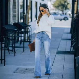 Jean évasé taille haute bleu clair pour femme avec ourlet à franges et pull à col roulé blanc