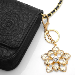 Sparkling crystal flower keychain with rhinestones on a black camellia embossed bag