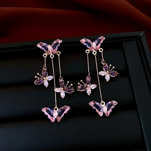 Detail of rose gold butterfly tassel earrings with purple and pink zircon stones