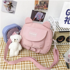 Detailed view of pink canvas crossbody bag with animal ears and cute bear charm
