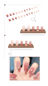 Detail of French plaid press-on nails with pink gradient, 3D hearts and rhinestones