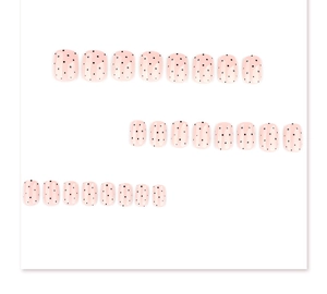 Detailed flat lay of pink square press-on nails with minimalist black polka dots