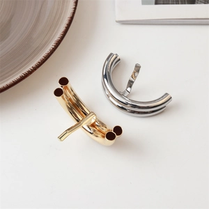 Close-up of minimalist gold and silver metallic lava hair clips on a white background
