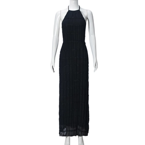 Detailed view of black tiered pleated fabric on a backless halter maxi dress for women
