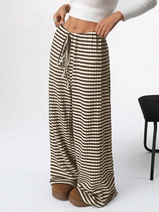 Detail of high-waisted wide-leg knit trousers with brown and white stripes and drawstring waist