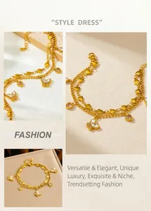 Detail of double-layer gold bracelet with crystal butterfly and solid heart charms