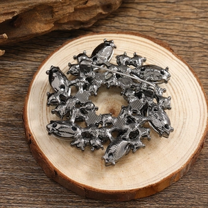 Deep grey rhinestone bauhinia flower brooch back view on wood base for suits