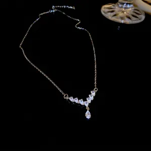 Elegant V-shaped silver drop necklace with clear zircon stones on a dark background