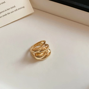 Detailed view of a triple-layered gold overlapping ring with minimalist fluid design