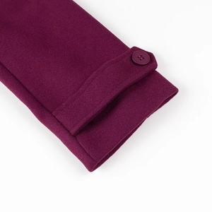 Détail de la manche d'un manteau en laine violet avec bride et bouton assorti
