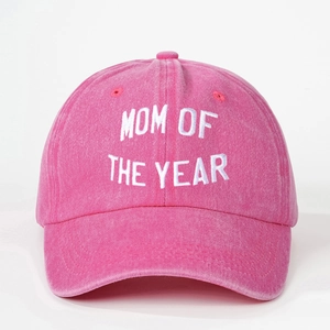 Detailed close-up of Mom of the Year white embroidery on washed pink baseball cap