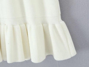 Vista macro dettagliata della trama in maglia bianca e degli eleganti bordi con volant