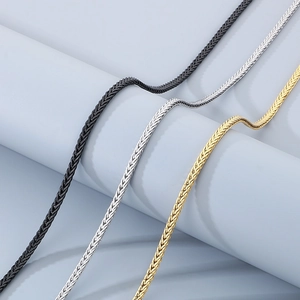 Macro detail of braided Chopin chains in black, silver, and gold stainless steel finishes