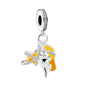 Macro shot of silver seashell and yellow enamel starfish charm with zircon stones