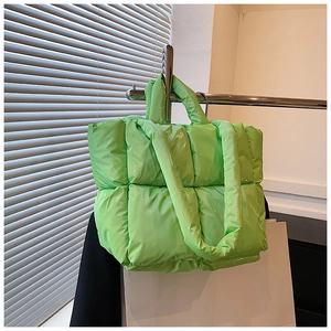 Detail of bright green quilted tote bag with soft padded texture and glossy finish