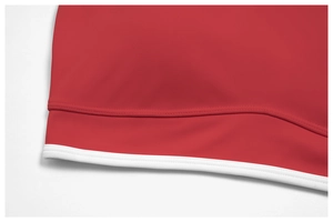 Detail of red yoga top featuring white contrast trim and durable double-needle stitching