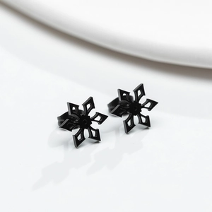 Close-up of minimalist black snowflake stud earrings in matte stainless steel with hollow design