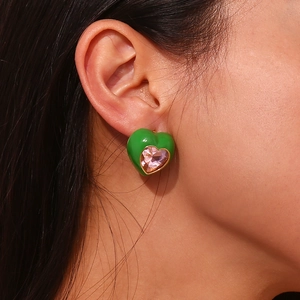 Gros plan sur les boucles d'oreilles cœur en plaqué or 18K avec émail vert et zircon rose
