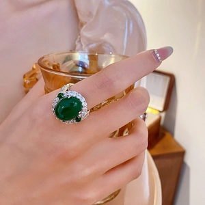Detail of vintage silver ring with oval emerald zircon and double layer of diamonds
