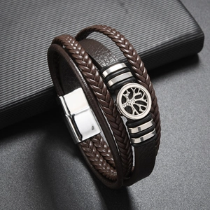 Detail of multi-layer brown braided leather bracelet with Tree of Life metal charm