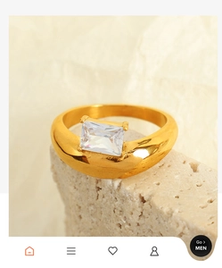 Detail of 18k gold plated ring with emerald-cut zircon on a natural stone base