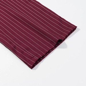 Detail of burgundy pinstripe suit trousers showing clean stitching and fabric texture