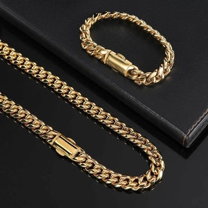 Gros plan d'un ensemble collier et bracelet maille gourmette 12mm en acier doré