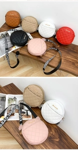 Macro shot of stylish round quilted crossbody bags in multiple colors on a wooden table